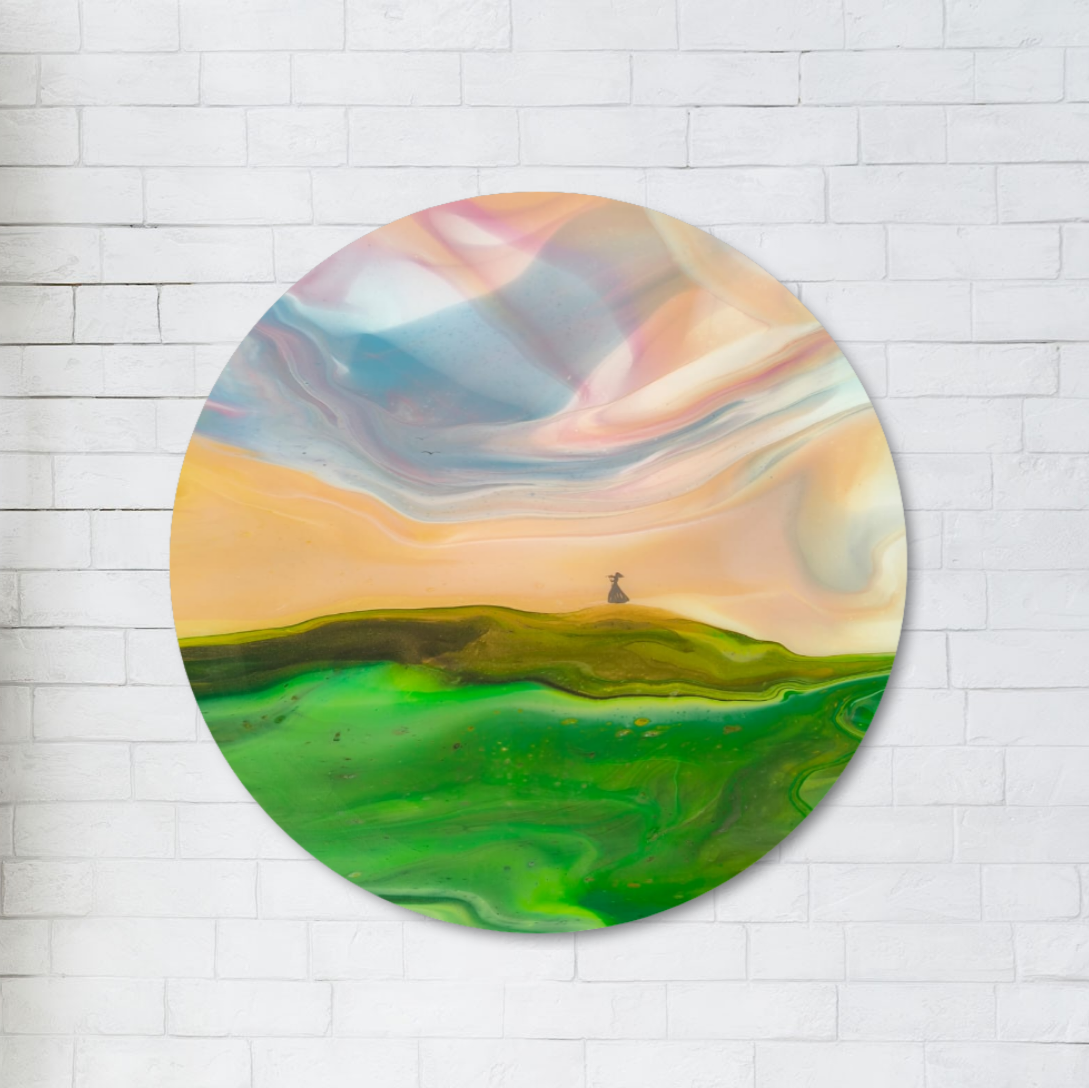 Round colourful abstract landscape painting on a white brick wall.